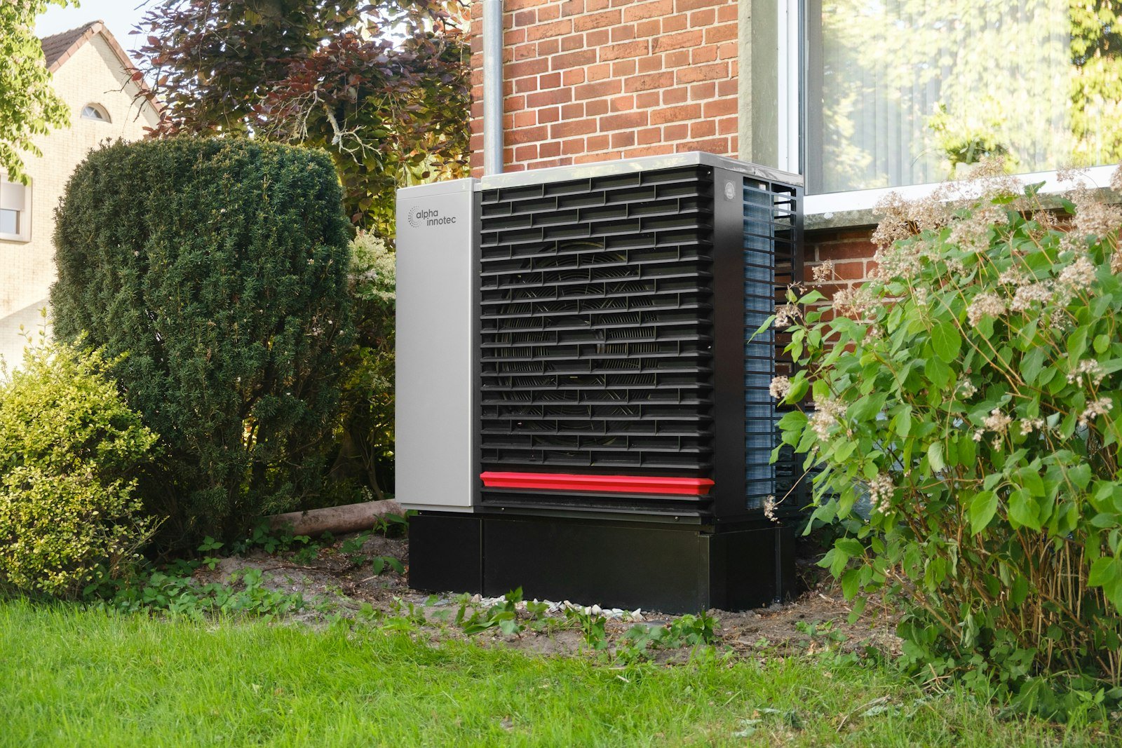 Wärmepumpe im Garten eines Einfamilienhauses